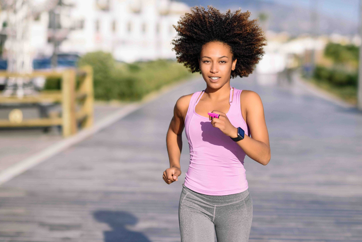 GoGuarded-5—woman-running-in-pink-with-afro strong woman runner